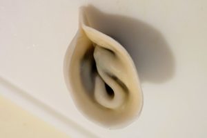 The dumpling folded in half so the two ends of the semi-circle are glued together - forming the shape of a pig's ear