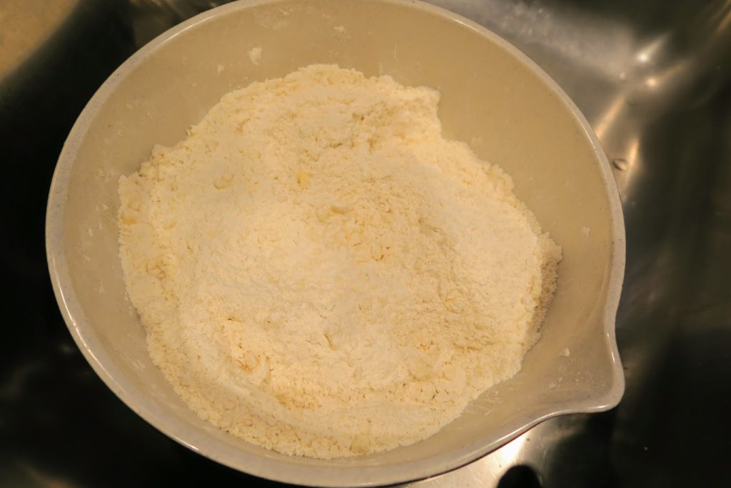 Flour combined with butter and salt in a bowl