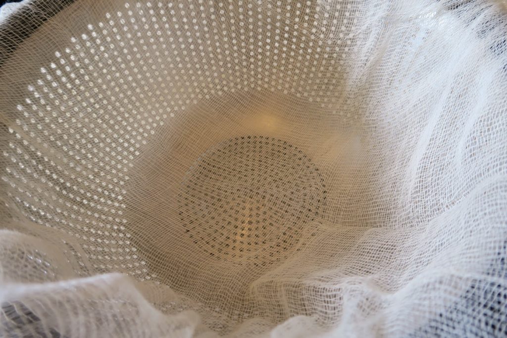 Cheesecloth covering a colander