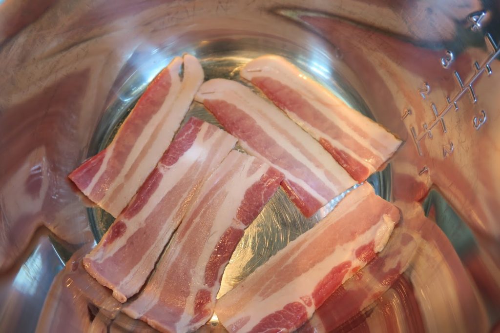 Halved pieces of uncooked bacon in the Instant Pot
