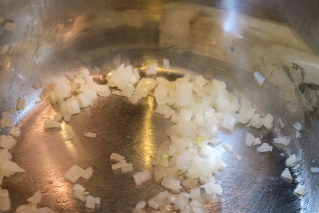 Chopped white onions being sauteed in the Instant Pot