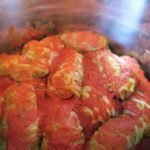 Cooked cabbage rolls inside the Instant Pot covered in tomato sauce