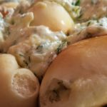 Baked Pyrizhky covered in cream sauce with dill