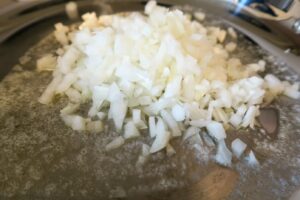 Chopped onions in a frying pan with oil and butter