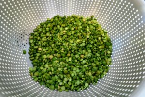 Rinsing dried peas in a colander