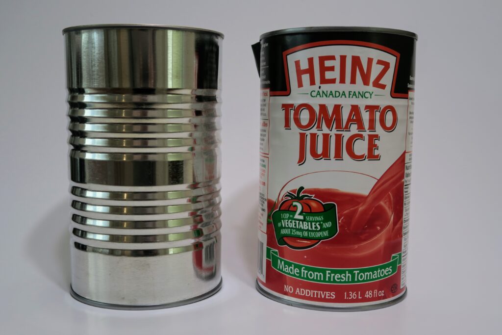 Two cans side by side, one without a label. The label reads Heinz Tomato Juice